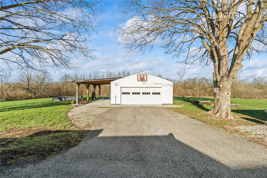 10797 Gratis Jacksonburg Road Somerville, OH 45064 - Photo 18 of 27 This property features a charming garage with an attached carport, set against a backdrop of natural beauty.