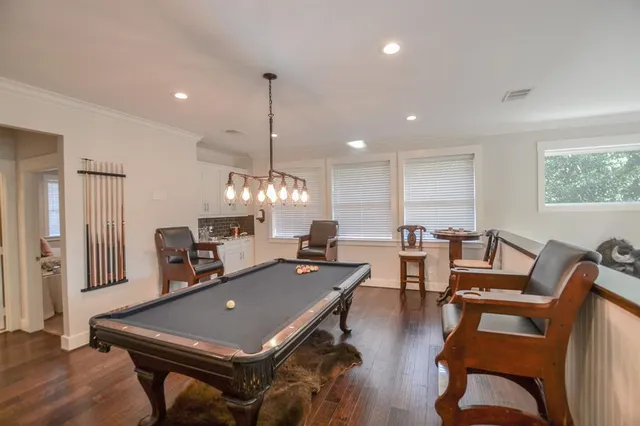 a room with furniture pool table and windows