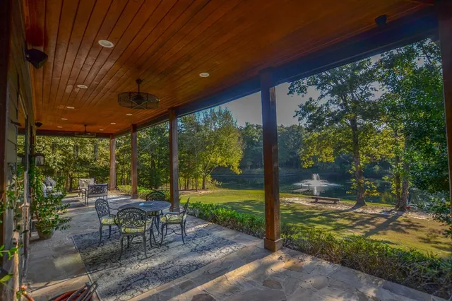 a view of a patio with table and chairs potted plants with large tree