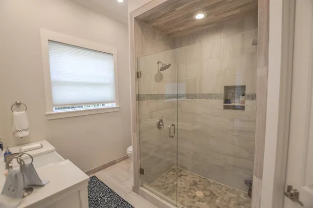 a bathroom with a granite countertop sink a toilet and shower