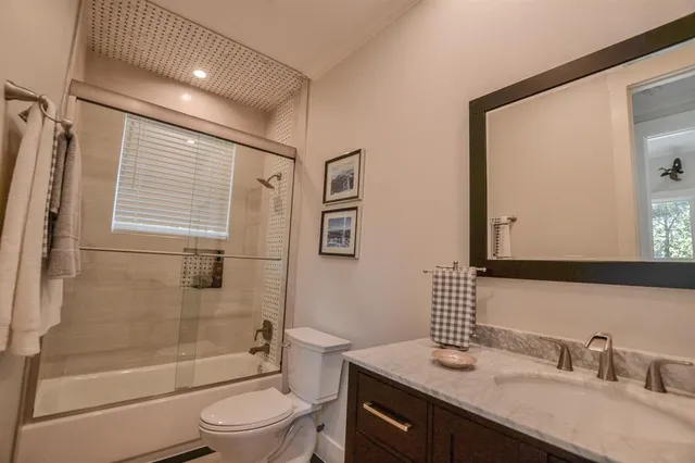 a bathroom with a granite countertop sink toilet and shower