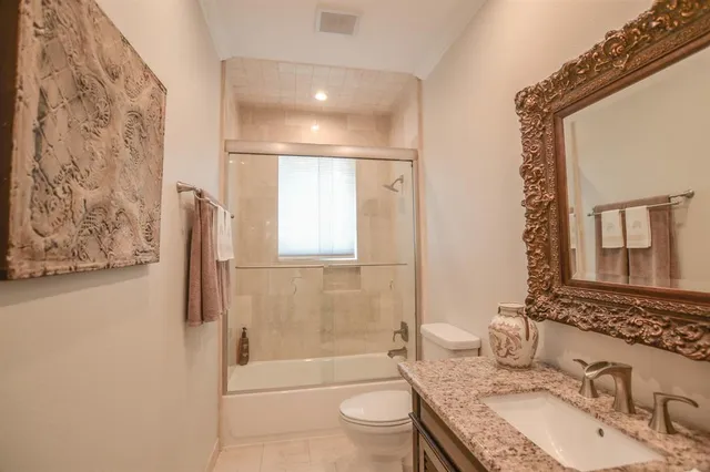 a bathroom with a granite countertop sink toilet and shower