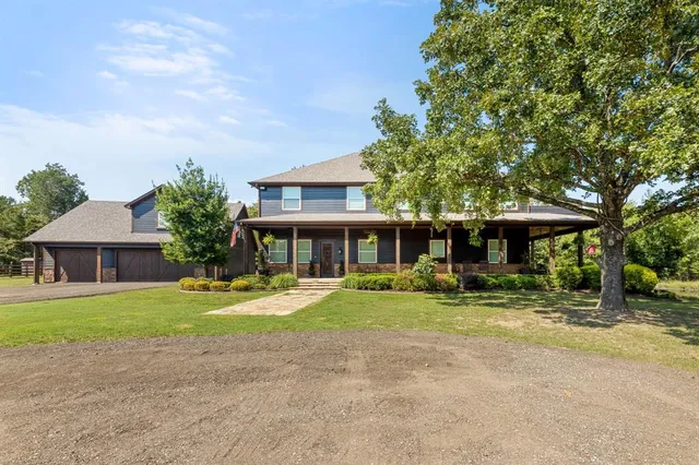 a front view of a house with a yard and trees
