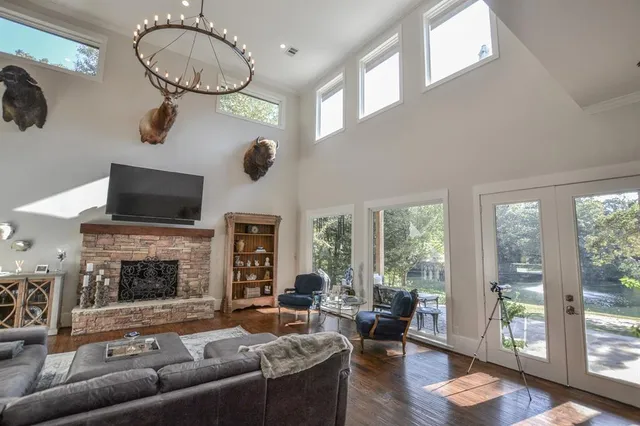 a living room with furniture a fireplace and a floor to ceiling window