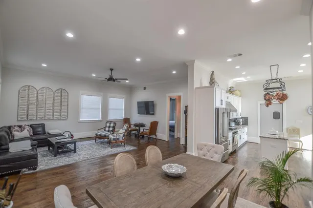a living room with furniture kitchen view and a chandelier