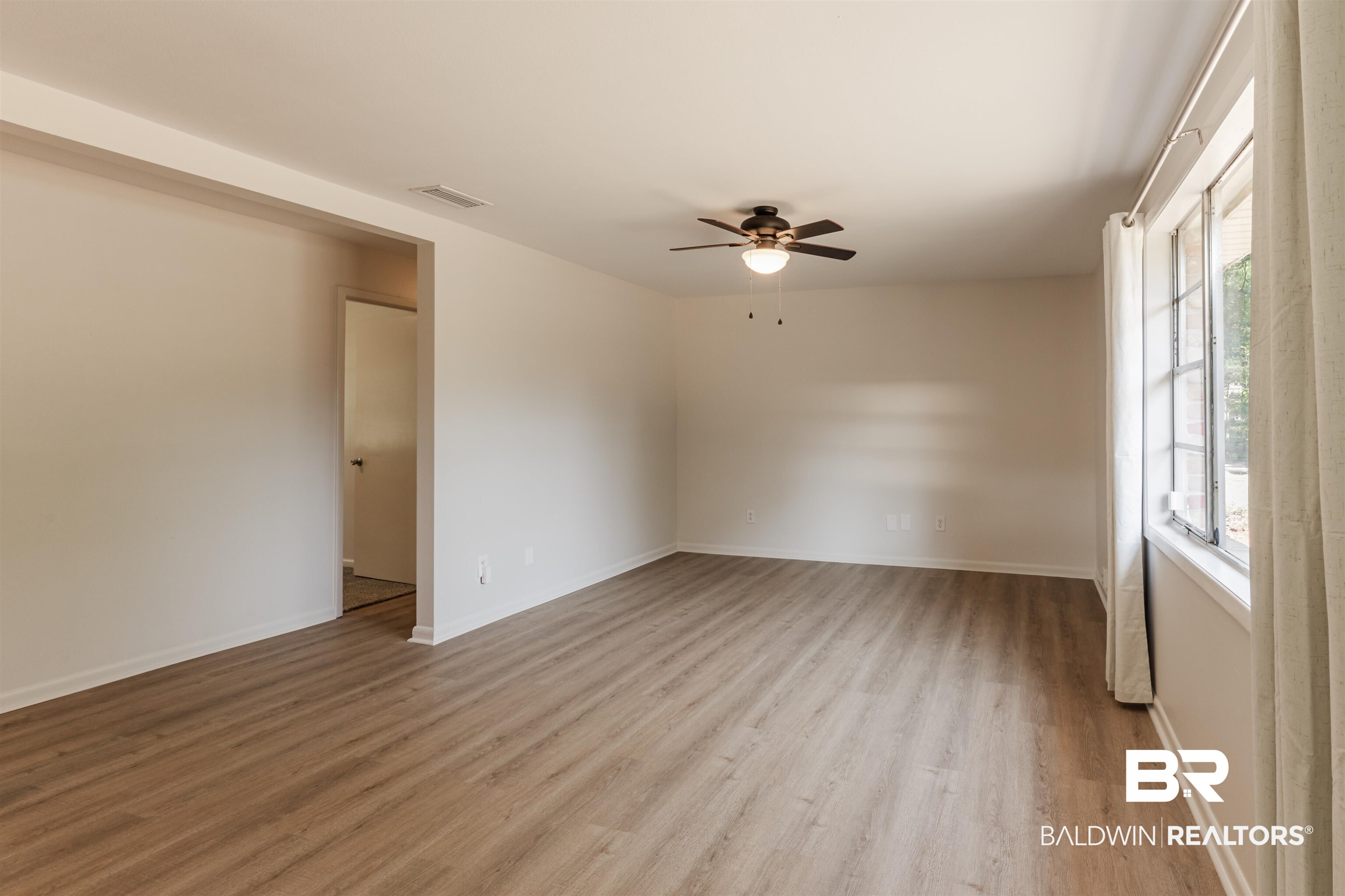 3970 Oak Ridge Avenue Mobile, AL 36619 - Photo 16 of 28 Unfurnished room featuring ceiling fan, a healthy amount of sunlight, and light hardwood / wood-style flooring