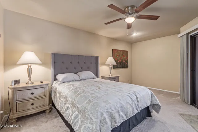 a bedroom with a bed a chandelier and a flat screen tv