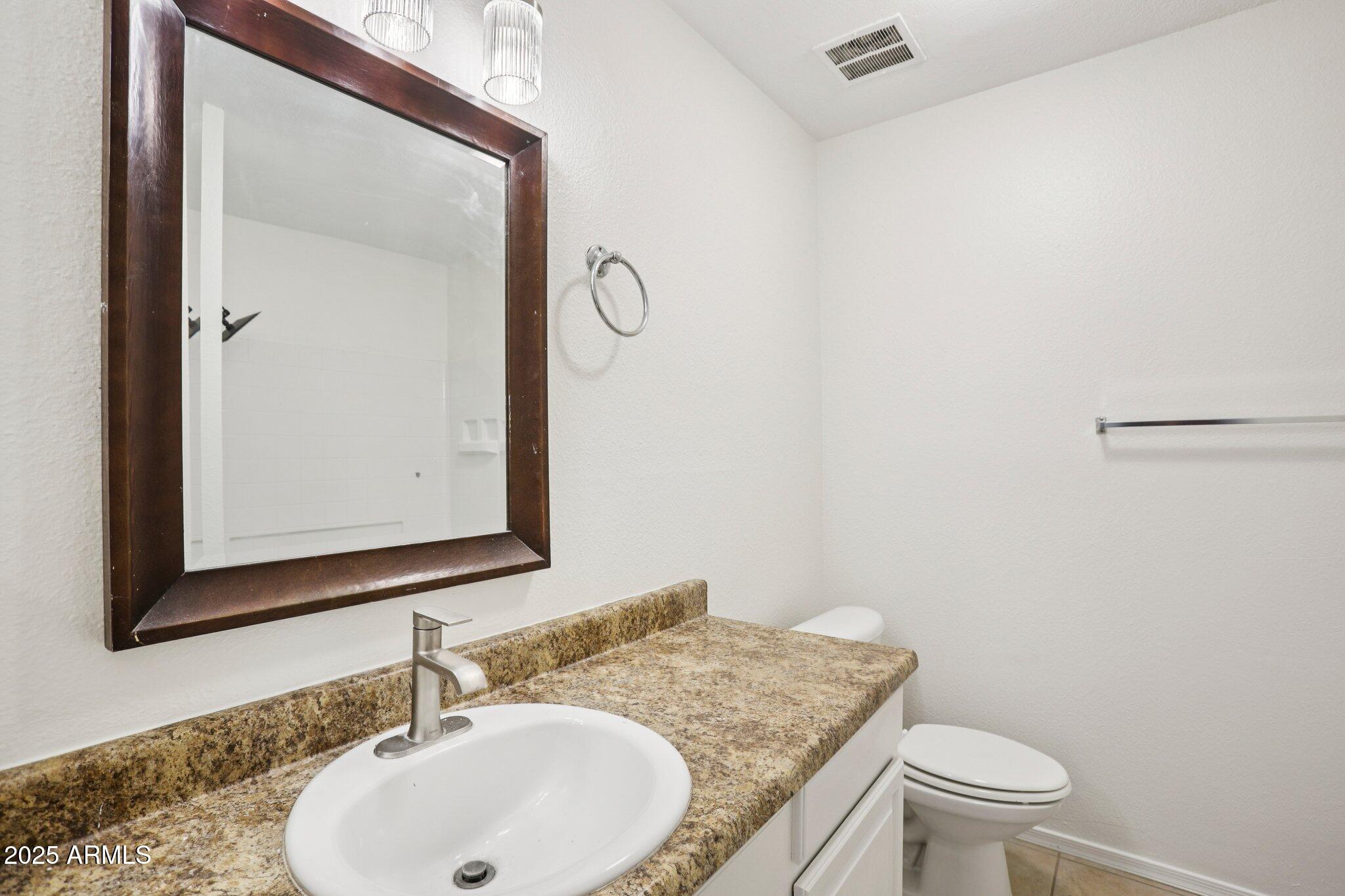 303 North Miller Road, Unit 1001 Scottsdale, AZ 85257 - Photo 11 of 20 a bathroom with a granite countertop sink a toilet and a mirror
