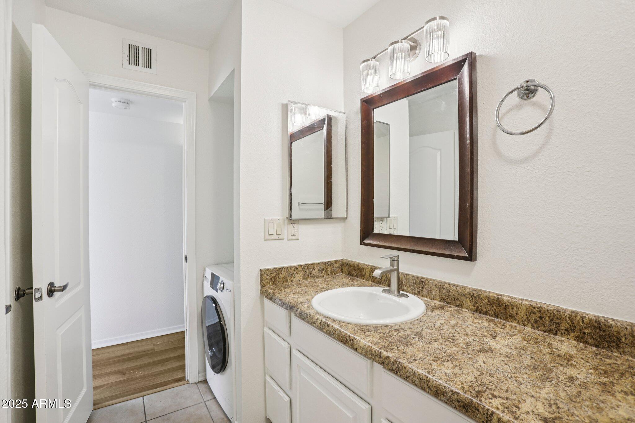 303 North Miller Road, Unit 1001 Scottsdale, AZ 85257 - Photo 13 of 20 a bathroom with a granite countertop sink and a mirror