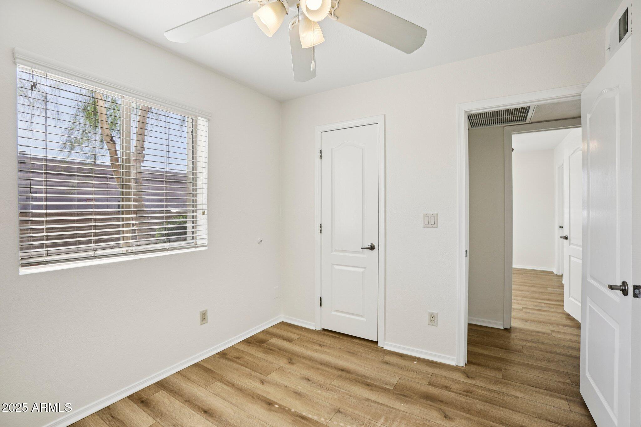 303 North Miller Road, Unit 1001 Scottsdale, AZ 85257 - Photo 15 of 20 a view of an empty room with wooden floor and a window