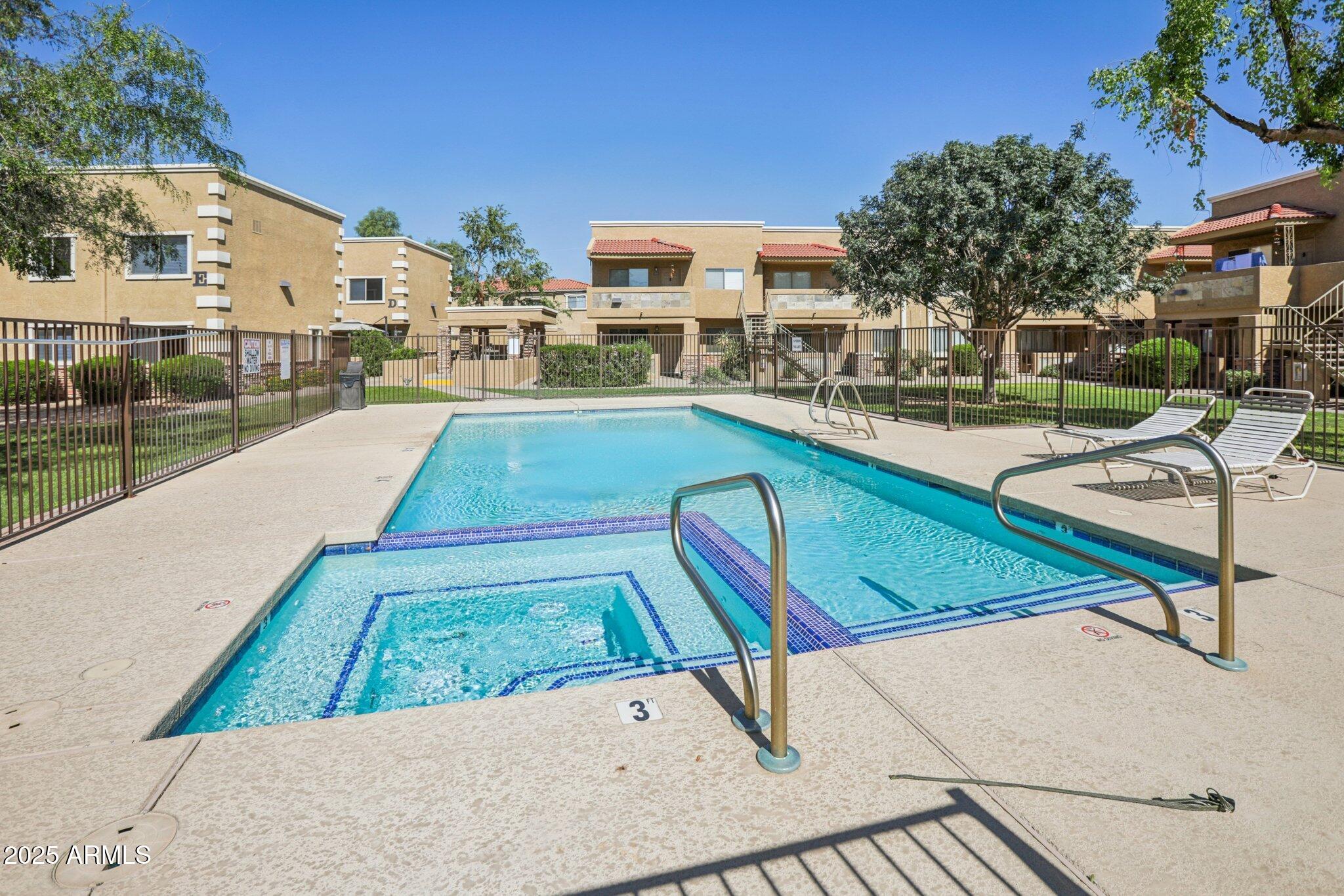 303 North Miller Road, Unit 1001 Scottsdale, AZ 85257 - Photo 20 of 20 a view of a swimming pool with a lounge chairs