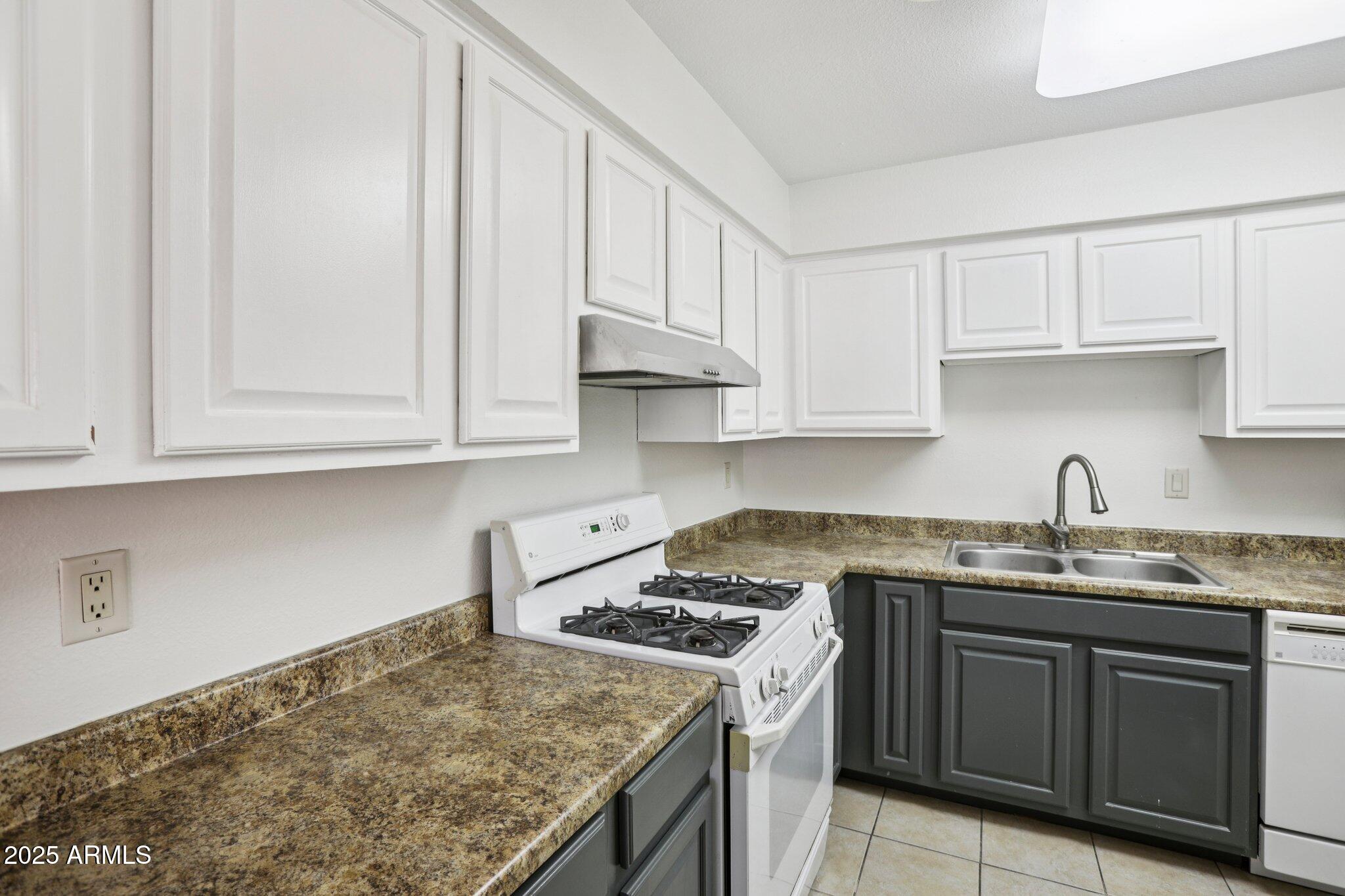 303 North Miller Road, Unit 1001 Scottsdale, AZ 85257 - Photo 9 of 20 a kitchen with stainless steel appliances granite countertop a sink stove and cabinets