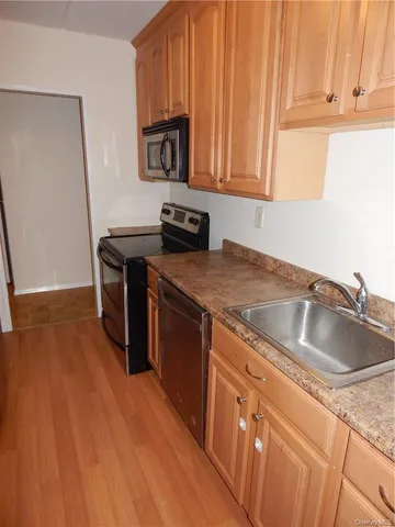 a kitchen with granite countertop a sink a stove and cabinets