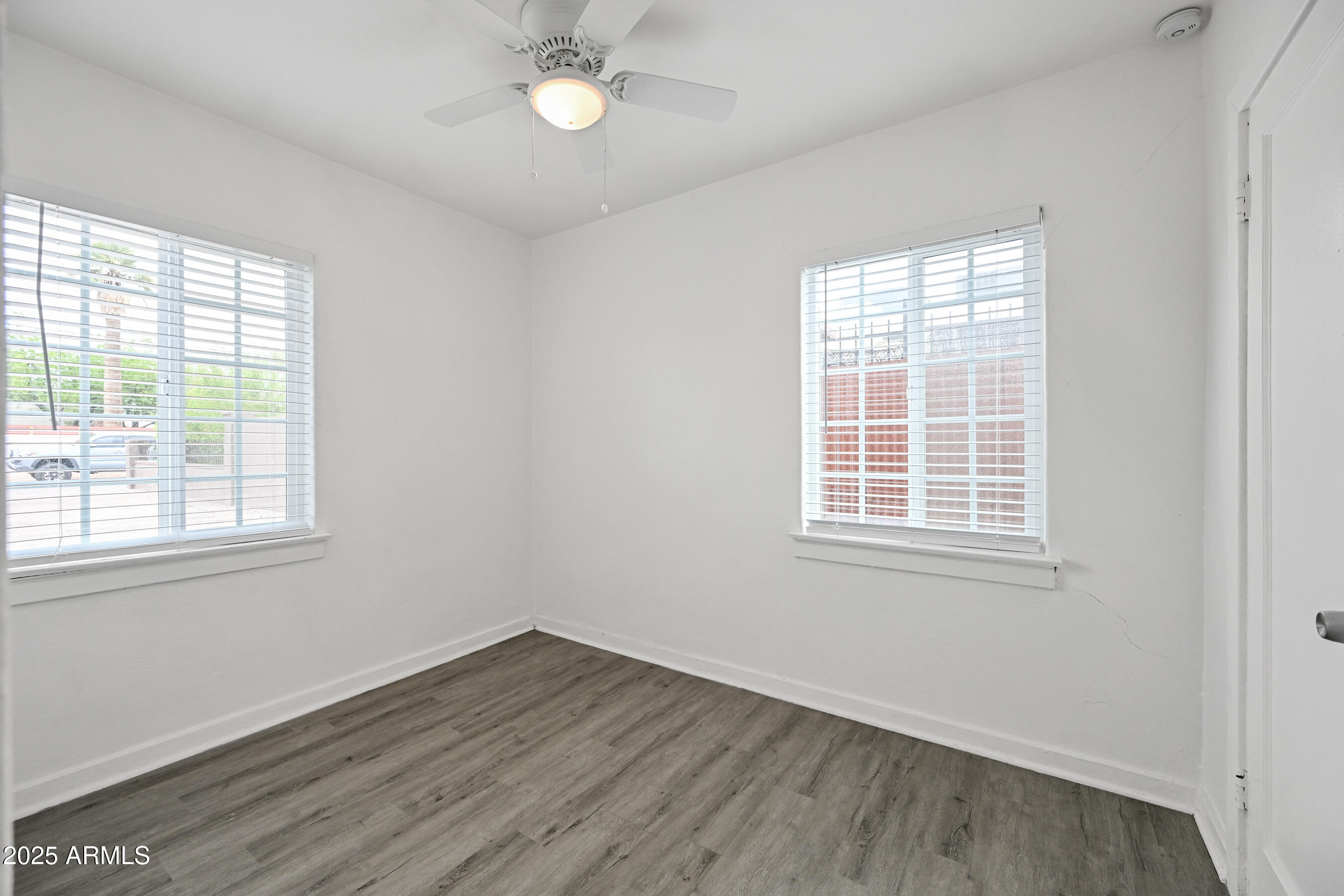 2709 North 7th Street Phoenix, AZ 85006 - Photo 1 of 14 an empty room with wooden floor and windows
