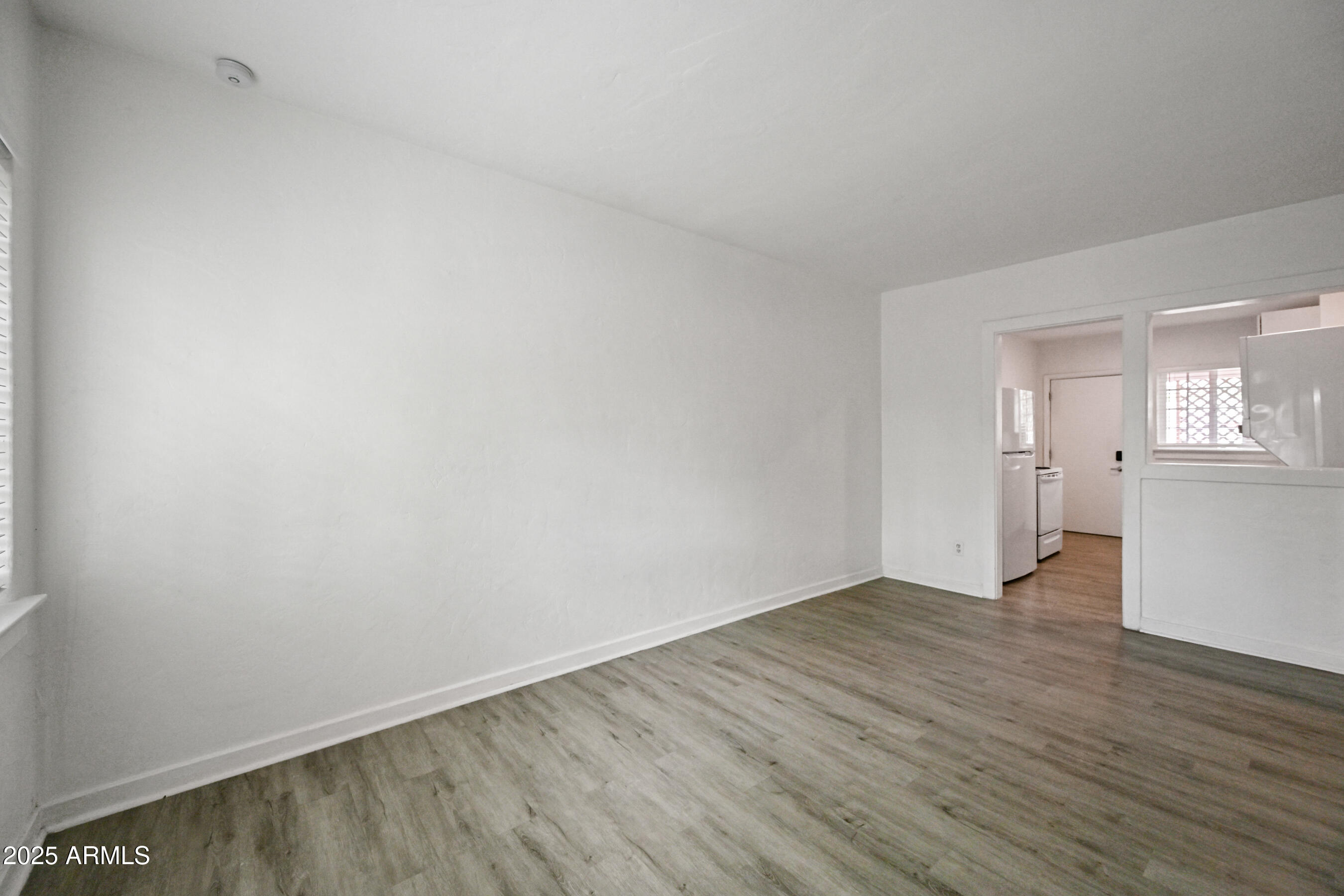 2709 North 7th Street Phoenix, AZ 85006 - Photo 6 of 14 an empty room with wooden floor and windows