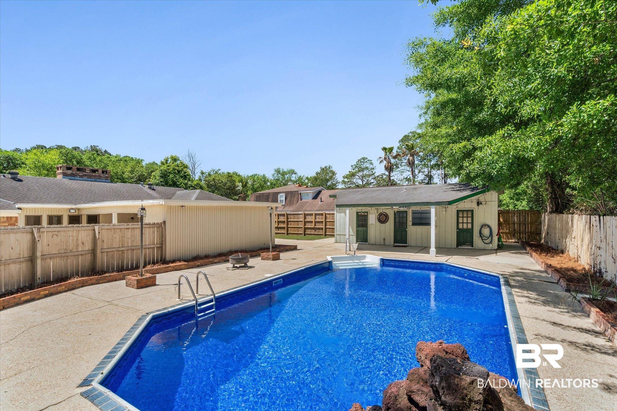 3724 Claridge Road South Mobile, AL 36608 - Photo 37 of 42 View of pool featuring an outdoor structure, a fenced backyard, patio surround, and an exterior structure