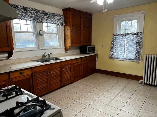 a kitchen with a sink a stove cabinets and a window