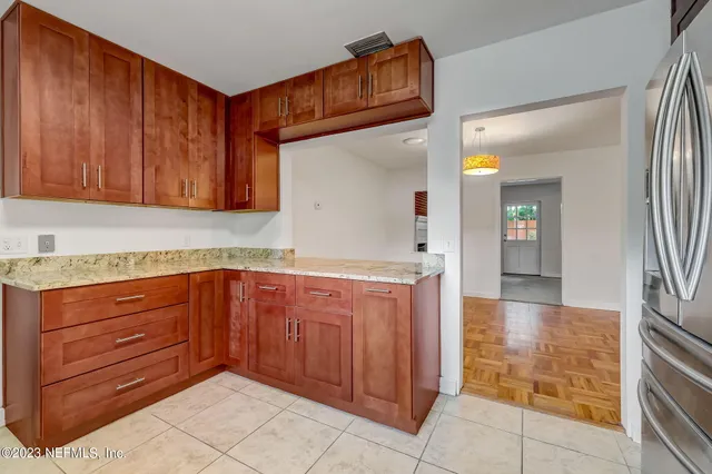 a kitchen with granite countertop wooden cabinets