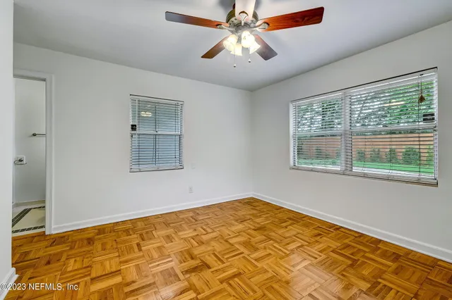 a view of a room with wooden floor and chandelier fan