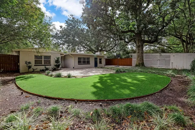 a view of a house with a backyard and a patio
