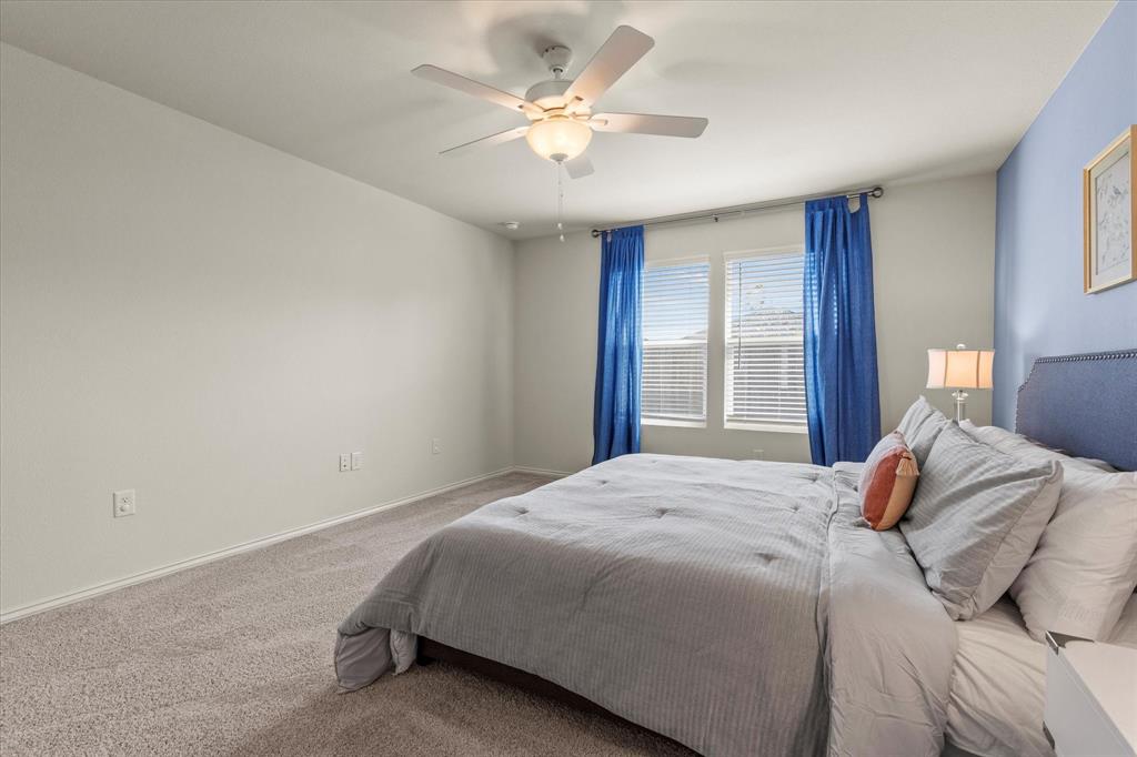 14056 Ilderton Street Pilot Point, TX 76258 - Photo 17 of 34 a bedroom with a large bed and a ceiling fan