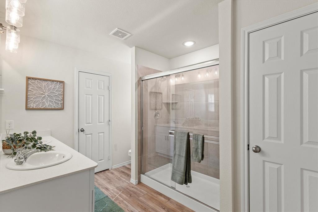 14056 Ilderton Street Pilot Point, TX 76258 - Photo 18 of 34 a bathroom with a sink a glass door and a mirror