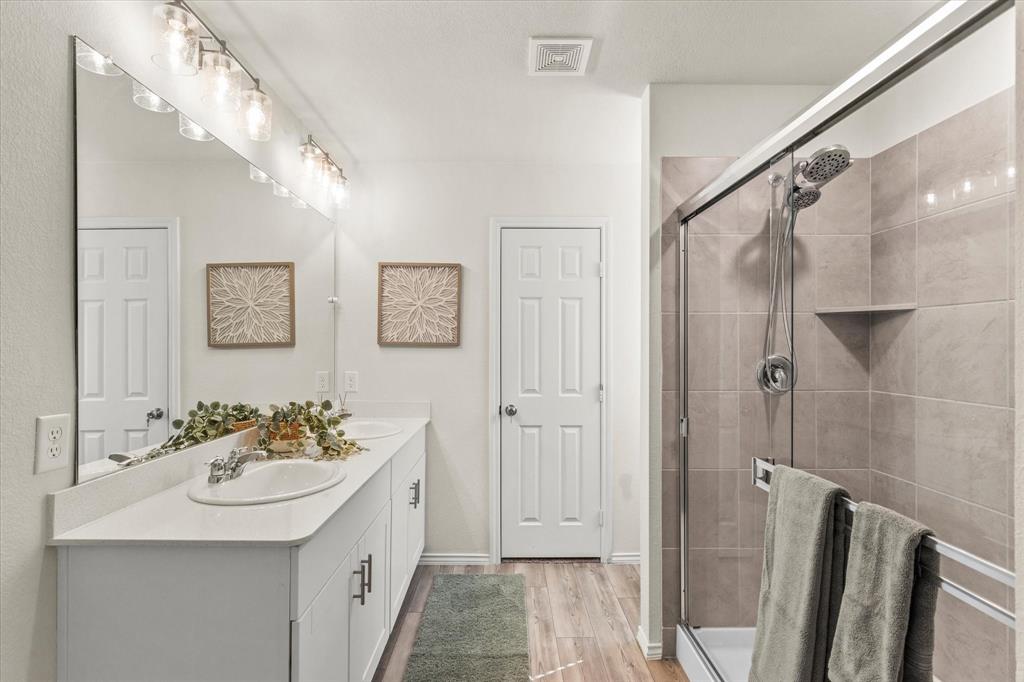 14056 Ilderton Street Pilot Point, TX 76258 - Photo 19 of 34 a bathroom with a sink a mirror a vanity and shower