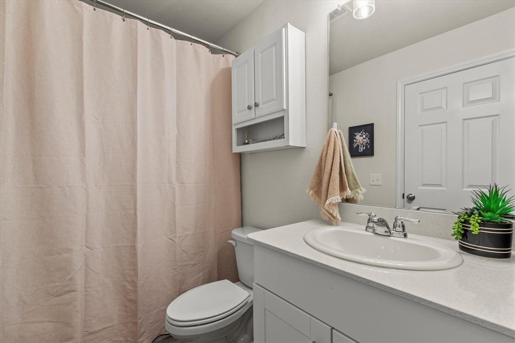14056 Ilderton Street Pilot Point, TX 76258 - Photo 23 of 34 a bathroom with a sink toilet and shower