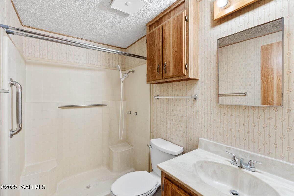 14012 Holly Road Mayer, AZ 86333 - Photo 14 of 28 a bathroom with a sink toilet and shower
