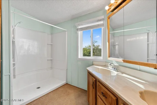 a bathroom with a shower sink and mirror