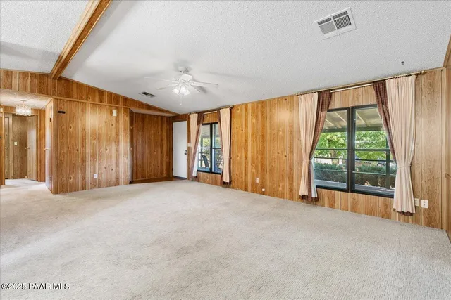a view of an empty room with a window and closet area