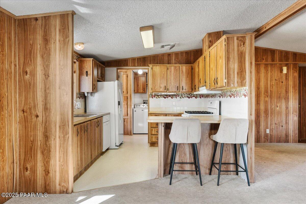14012 Holly Road Mayer, AZ 86333 - Photo 9 of 28 a kitchen with stainless steel appliances kitchen island granite countertop furniture a refrigerator and a sink
