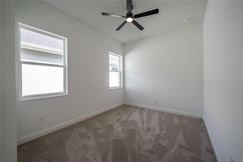 4727 Southeast 25th Loop Ocala, FL 34480 - Photo 21 of 29 an empty room with windows and fan