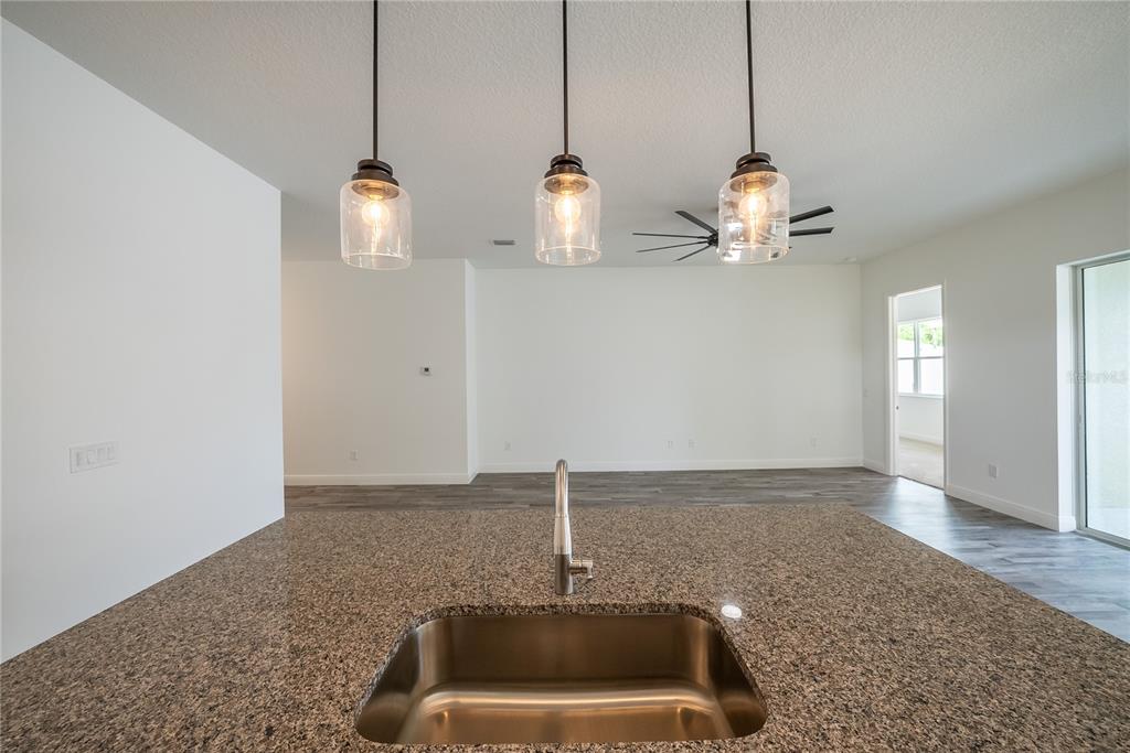 4727 Southeast 25th Loop Ocala, FL 34480 - Photo 5 of 29 a room with a chandelier fan and wooden floor