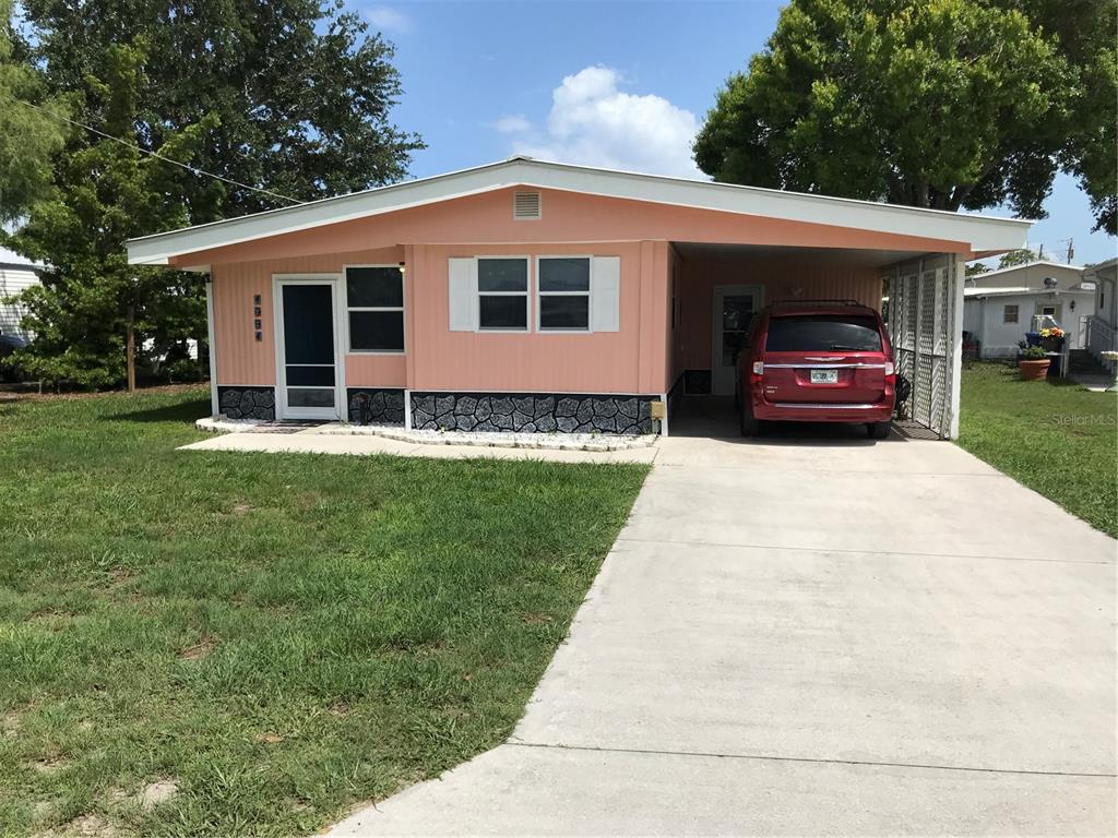 1091 Lemon Street Okeechobee, FL 34974 - Photo 1 of 19 a front view of a house with a garden and trees
