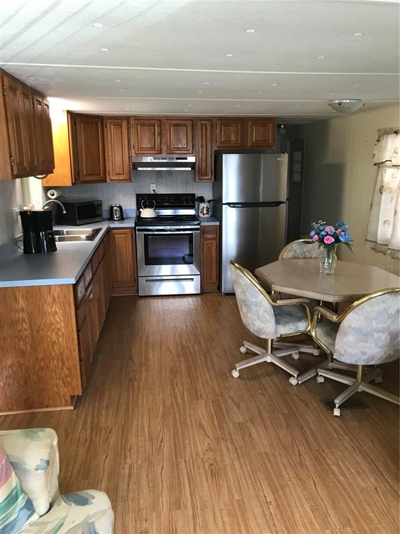 1091 Lemon Street Okeechobee, FL 34974 - Photo 3 of 19 a kitchen with kitchen island wooden floors appliances and cabinets