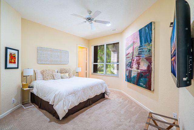 a bedroom with a large bed a painting and a window