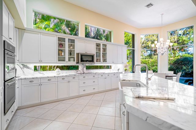 a kitchen with stainless steel appliances granite countertop a stove and a large window