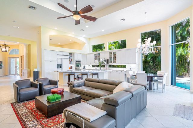 a living room with furniture kitchen view and large windows