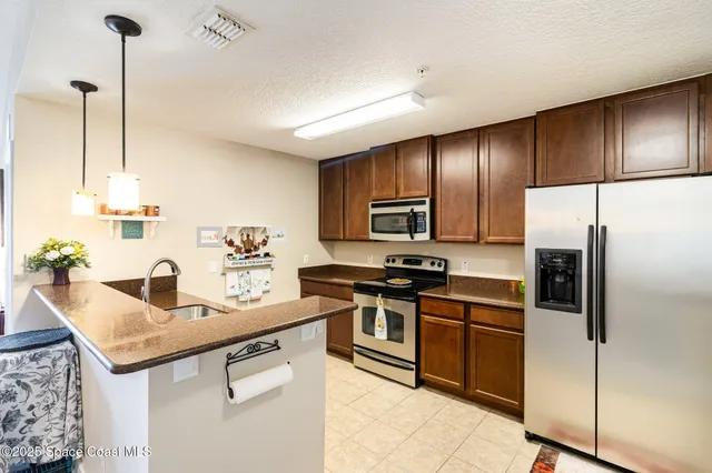 a kitchen with stainless steel appliances granite countertop a sink a stove and refrigerator