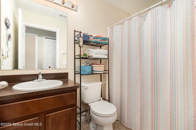 a bathroom with a sink a toilet and shower curtain