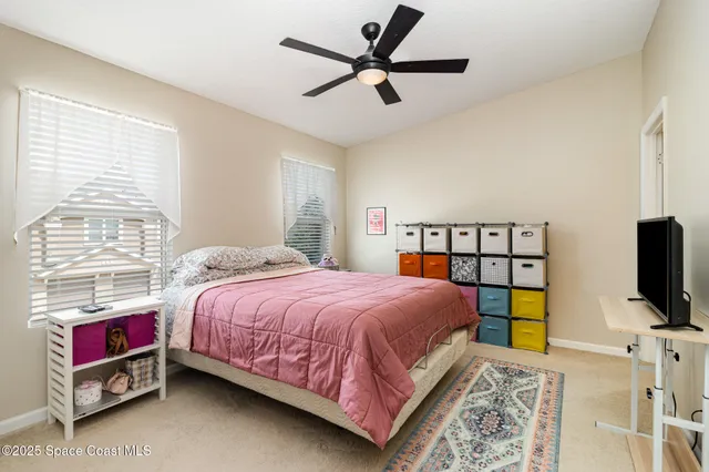 a bedroom with a bed a flat screen tv and a window