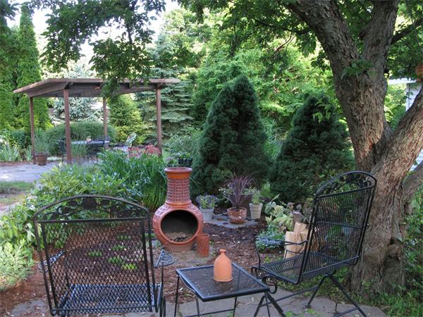 5 Garrison Road Wellesley, MA 02482 - Photo 16 of 19 a backyard with table and chairs potted plants and a large tree