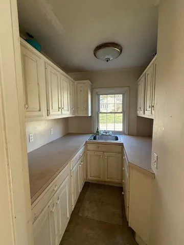 a kitchen with cabinets and window