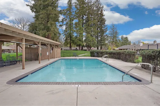 a view of a house with a yard and a large tree