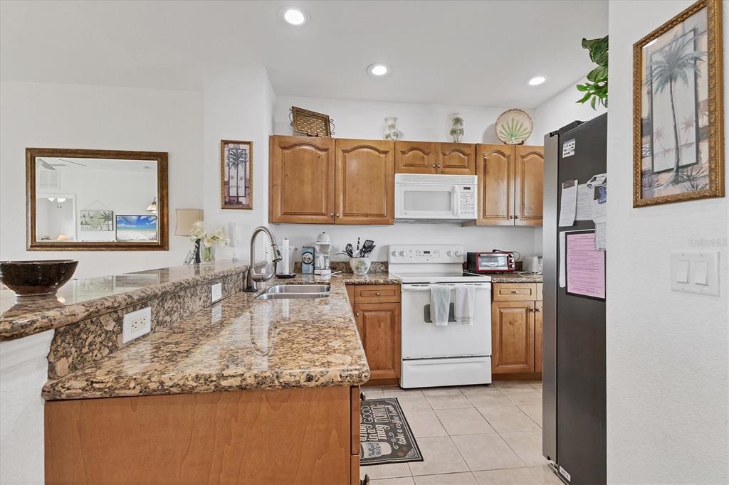 8411 Placida Road, Unit 404 Placida, FL 33946 - Photo 13 of 54 a kitchen with stainless steel appliances granite countertop a sink stove and refrigerator
