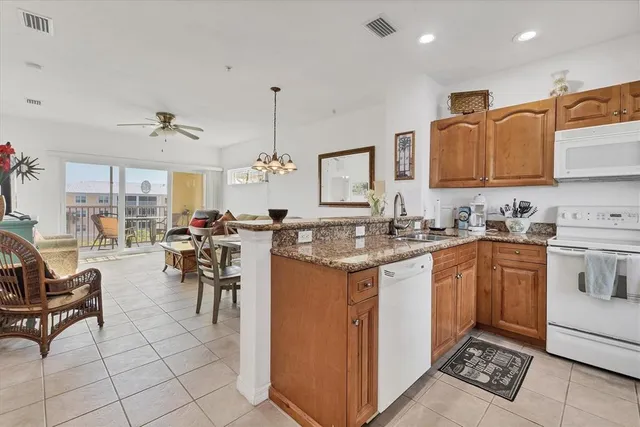 a kitchen with stainless steel appliances granite countertop a sink and a refrigerator