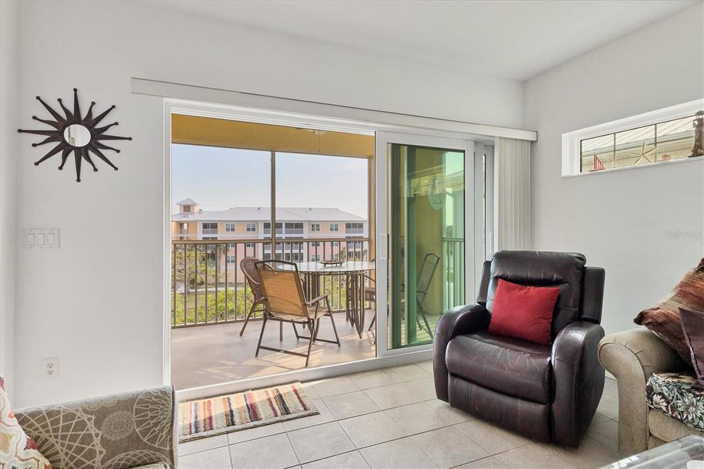 8411 Placida Road, Unit 404 Placida, FL 33946 - Photo 19 of 54 a living room with furniture and a floor to ceiling window