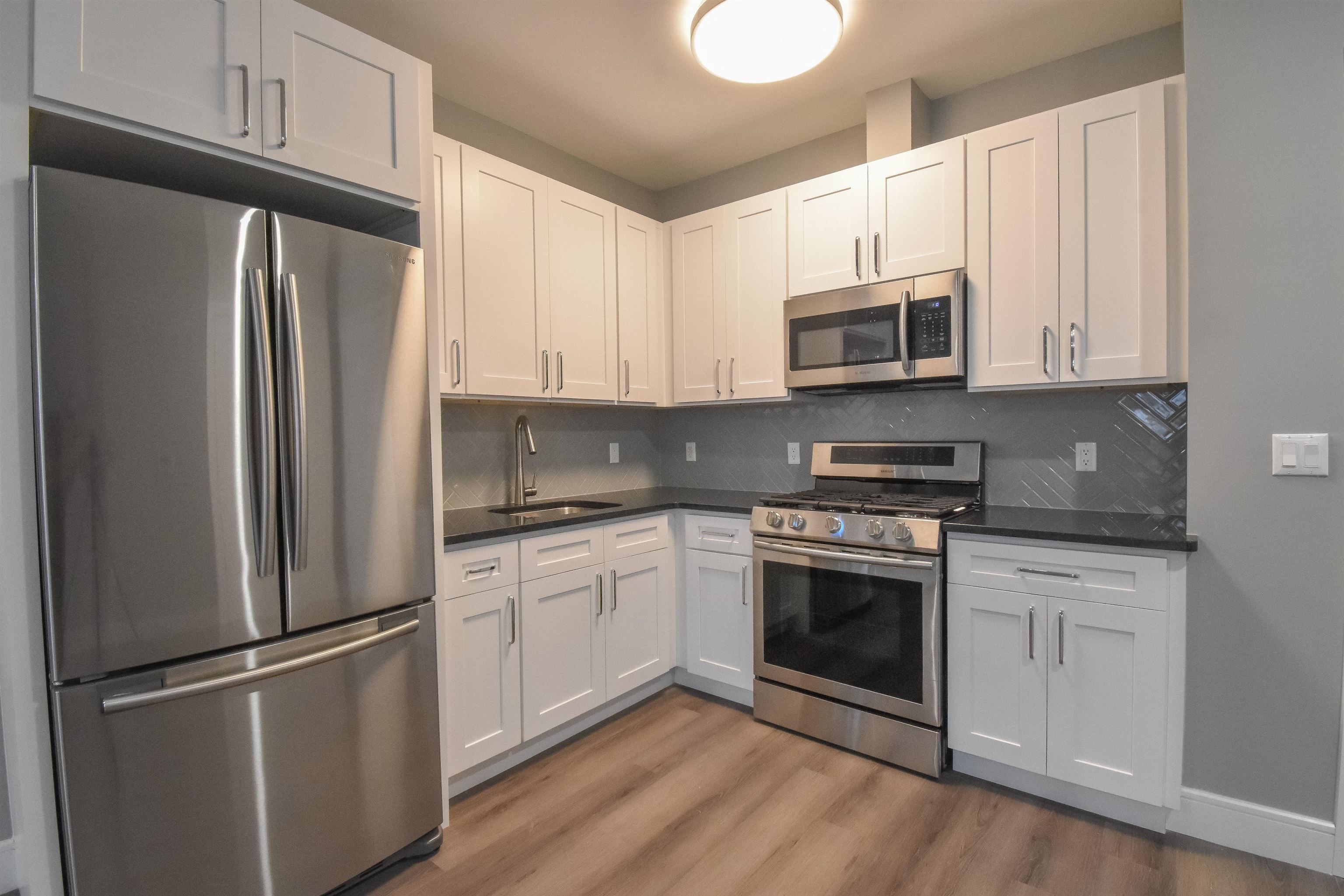 4201 Bergen Turnpike, Unit 2D North Bergen, NJ 07047 - Photo 1 of 12 a kitchen with stainless steel appliances white cabinets white stove a refrigerator and a microwave