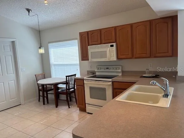 a kitchen that has a sink cabinets and wooden floor